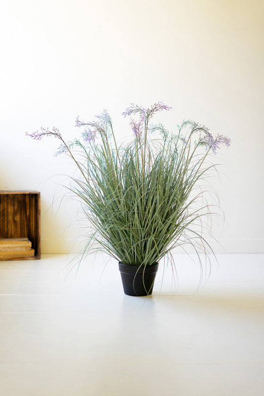 Artificial Grass with Flowers in a Black Plastic Pot