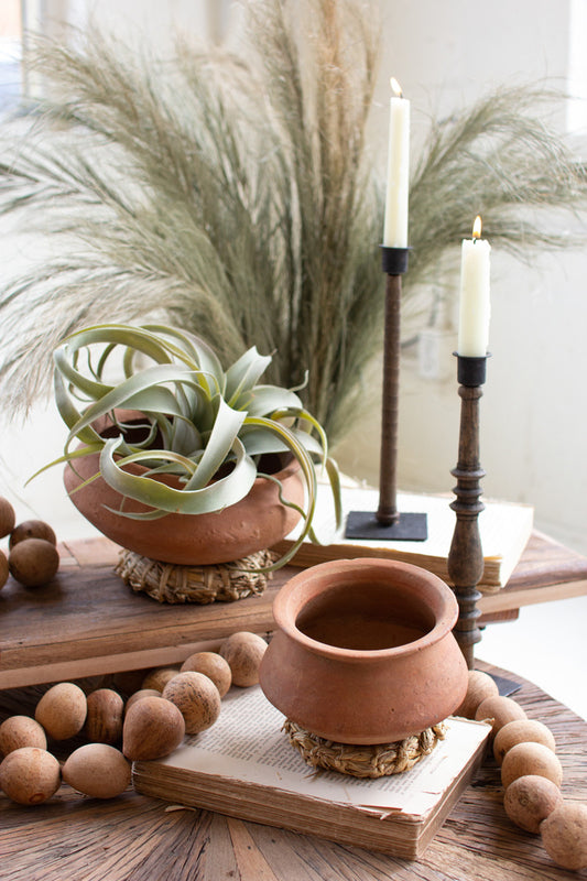 SET OF TWO TERRACOTTA VESSELS WITH WOVEN SEAGRASS BASES